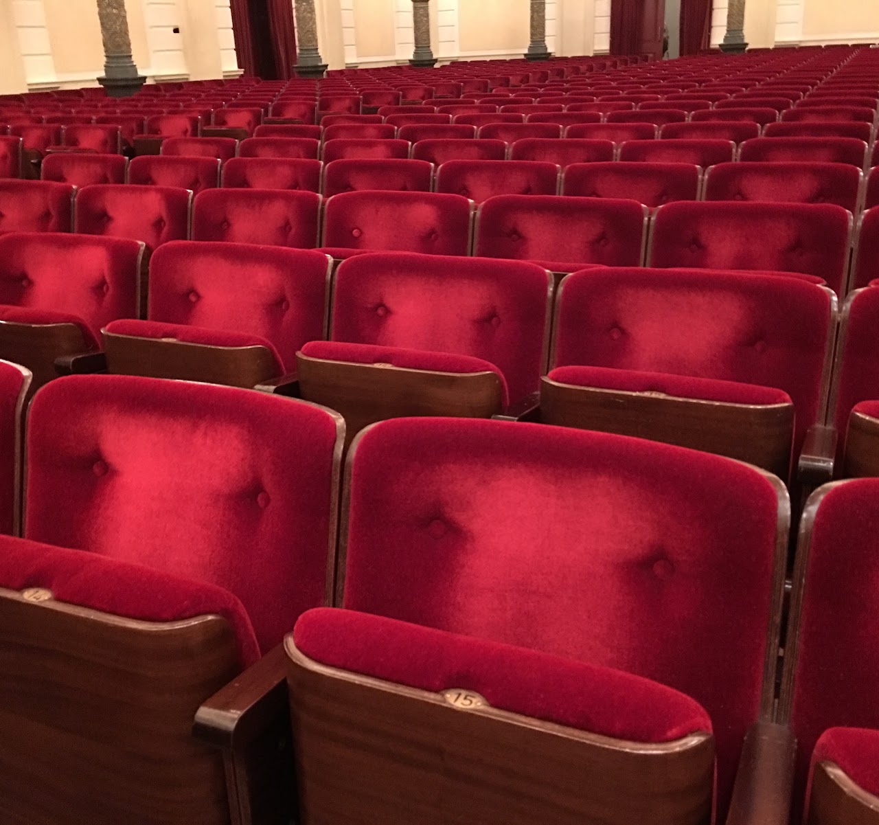 Rows of red velvet seats in an empty cinema